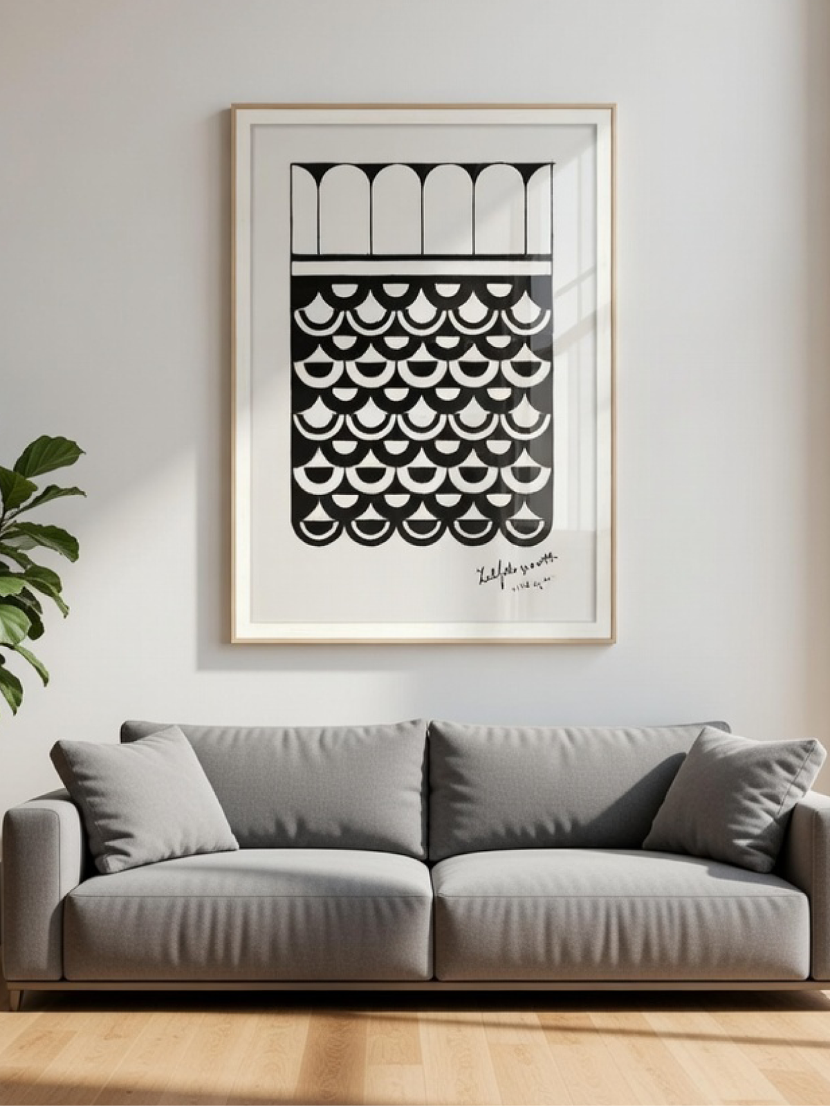 Framed black and white geometric abstract art print on a neutral wall with shadows above a grey sofa.