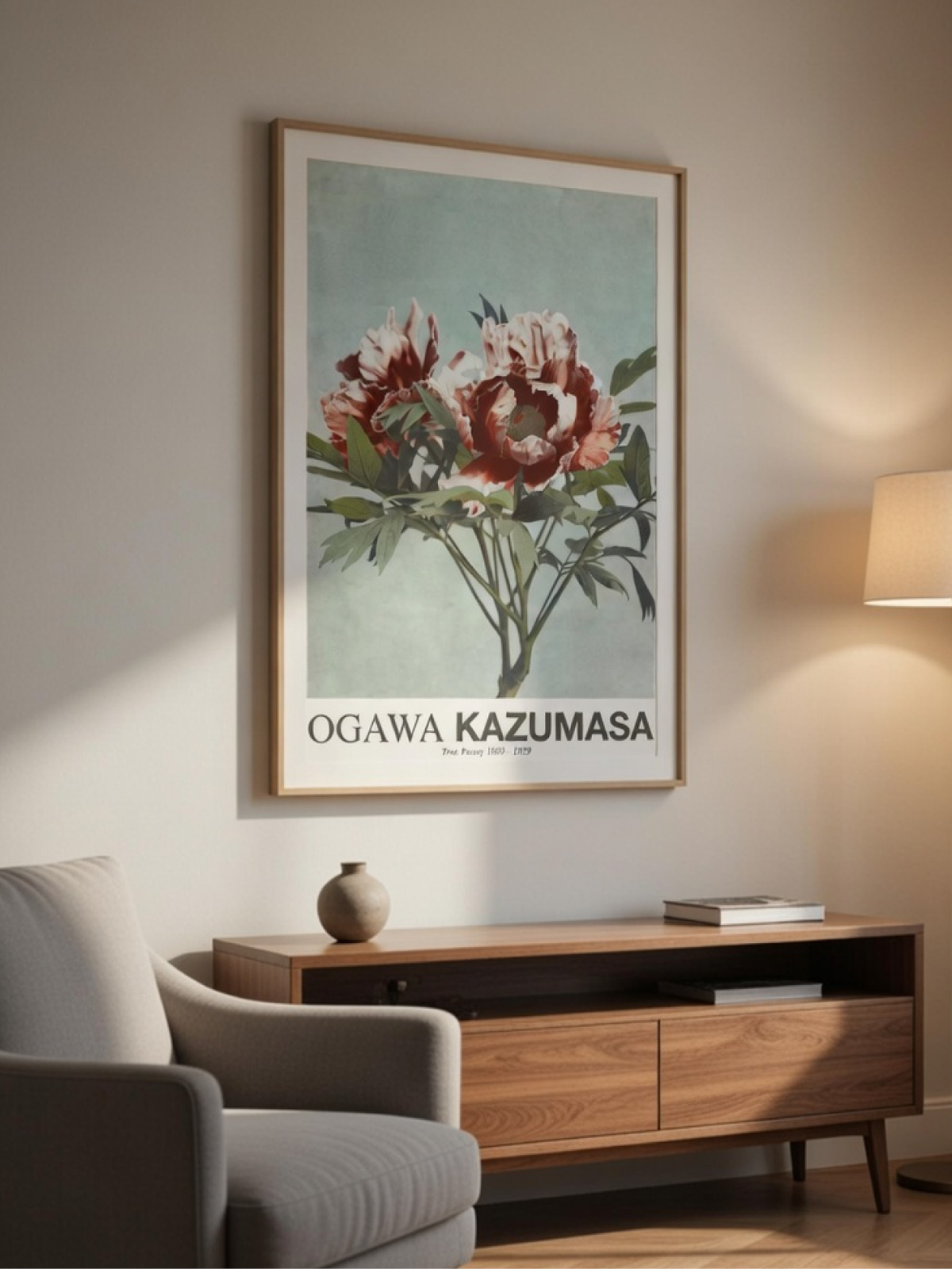 Framed Japanese floral art poster by Ogawa Kazumasa on a neutral wall above a low wooden console table.