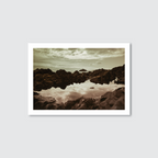 Framed photograph of a rocky landscape with water reflection on a light gray background