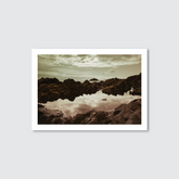 Framed photograph of a rocky landscape with water reflection on a light gray background