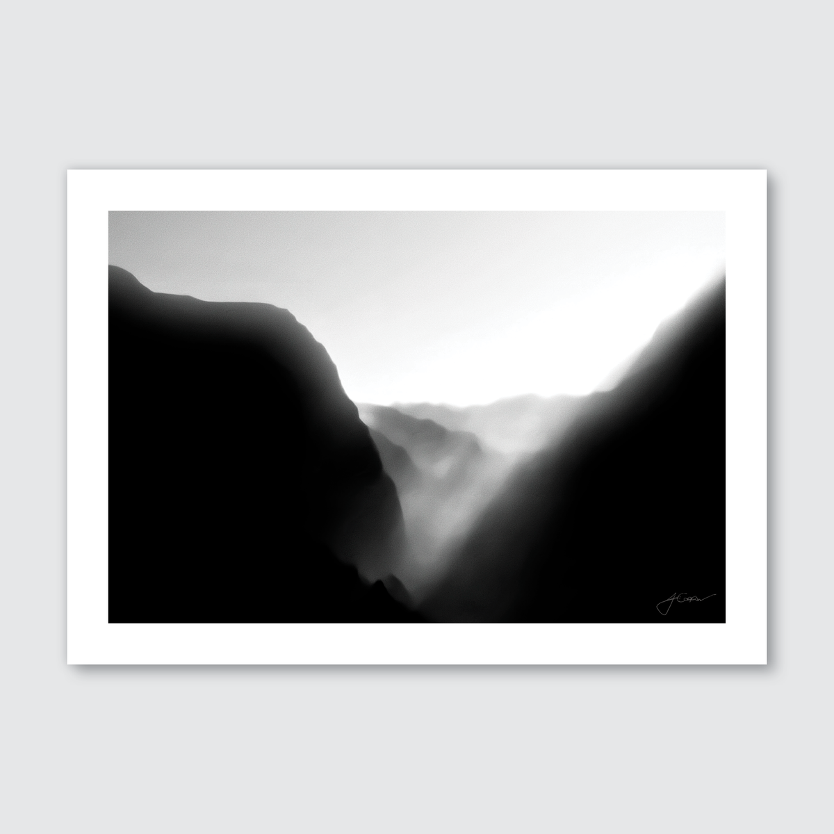 A monochromatic photograph of misty hills during sunset, with soft light diffusing through the mist and illuminating the rugged terrain.